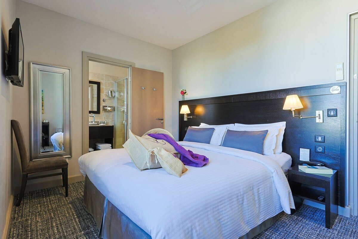 A hotel room with a bed and a mirror