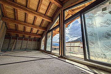 A building under construction with a lot of windows and a roof