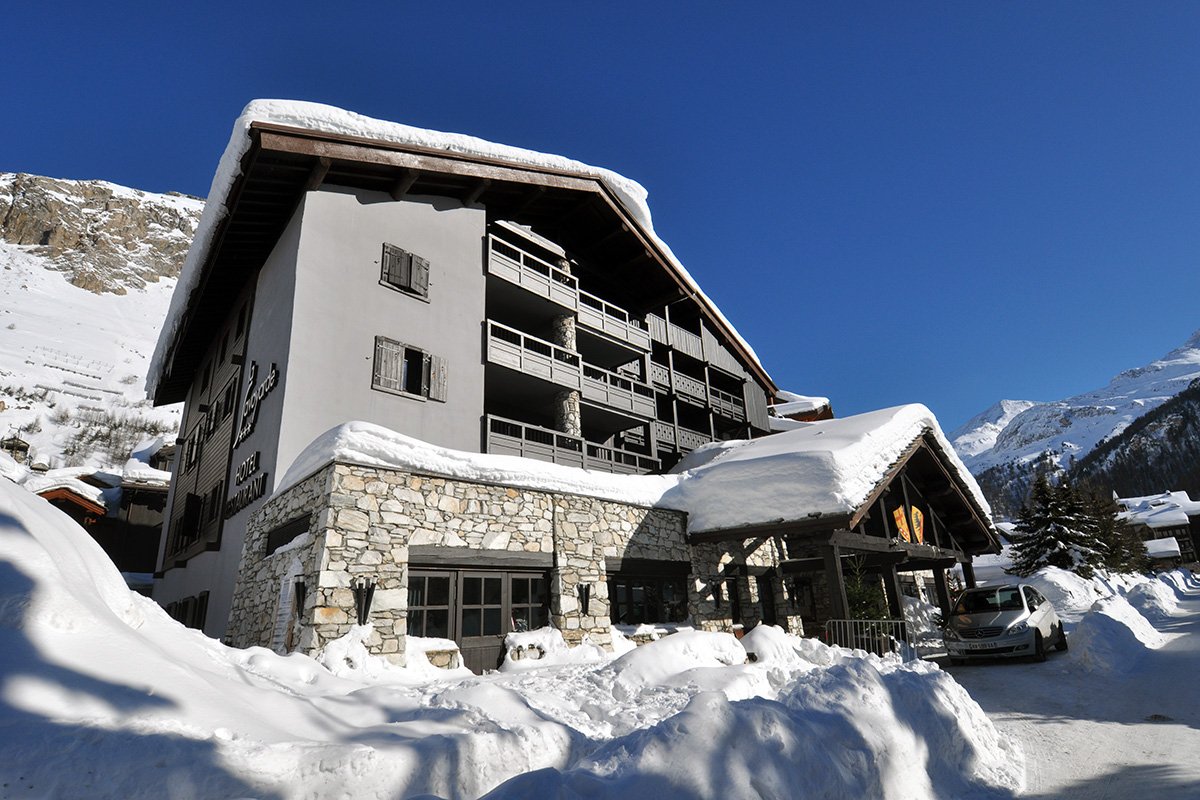 A snowy building with a sign that says ' hotel ' on it