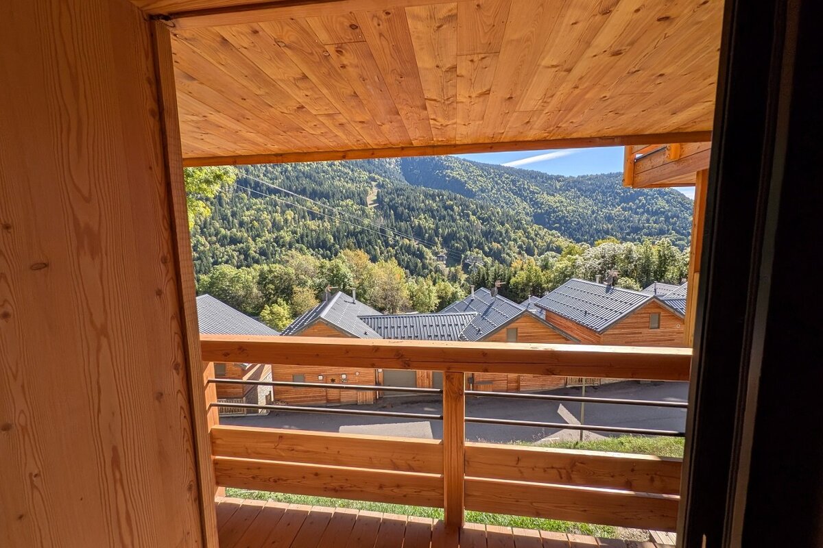 A balcony with a view of mountains and houses