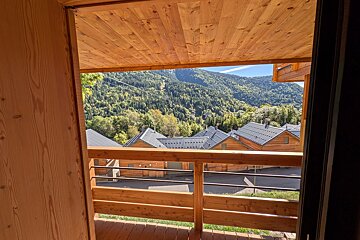 A balcony with a view of mountains and houses