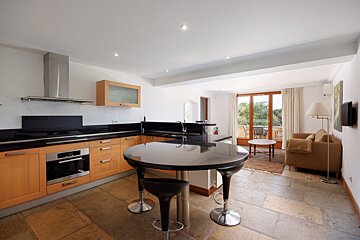A kitchen with wooden cabinets and black counter tops