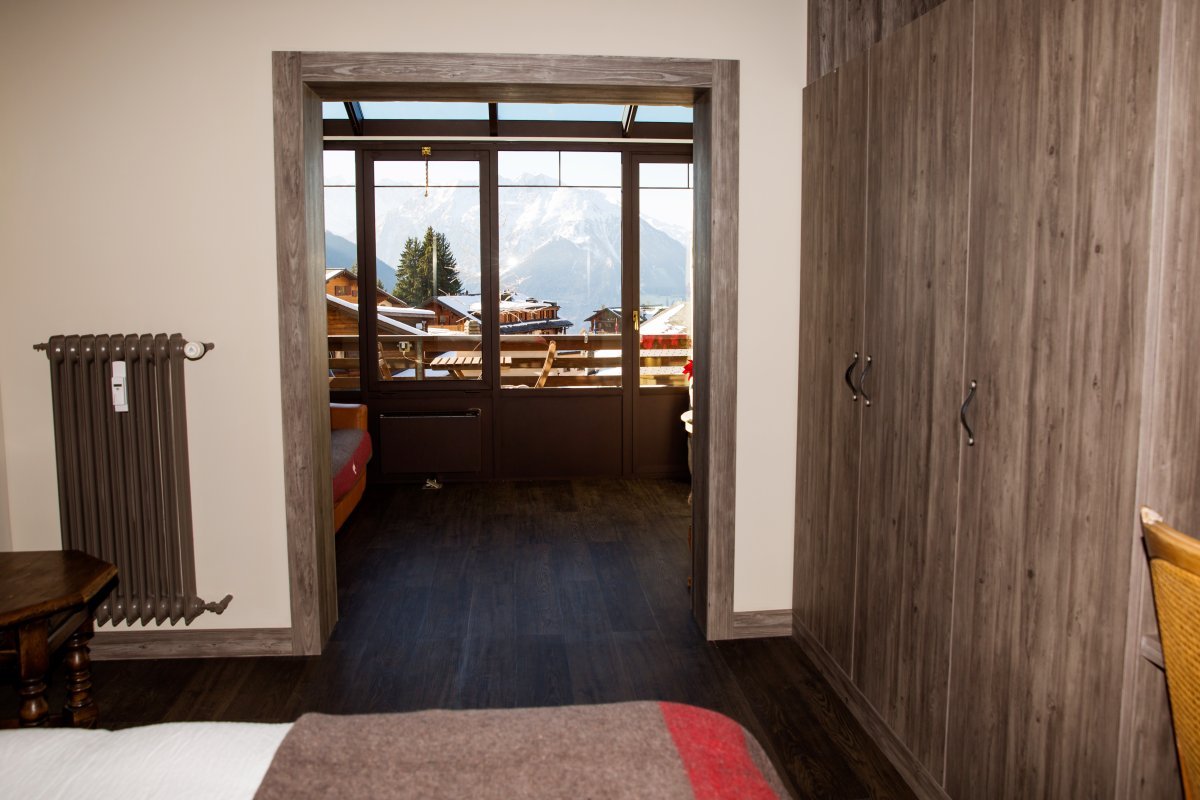 A bedroom with a sliding glass door leading to a balcony