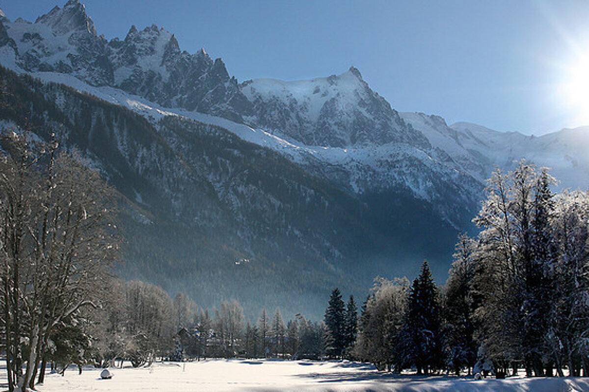 A snowy landscape with mountains in the background