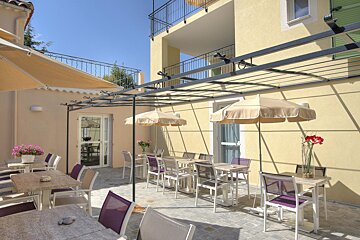 A patio area with tables and chairs under umbrellas