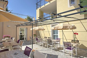 A patio area with tables and chairs under umbrellas