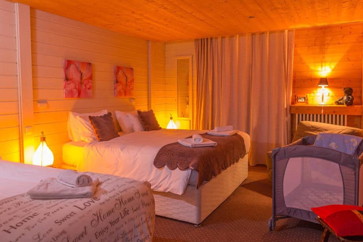 A bedroom with two beds and a crib that says home sweet love