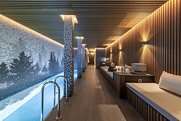 A long hallway leading to a swimming pool