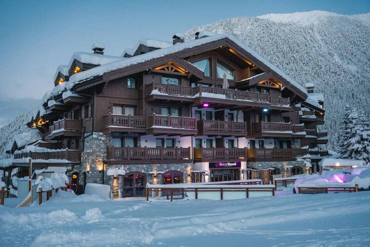 A snowy building with a purple sign that says berry hotel