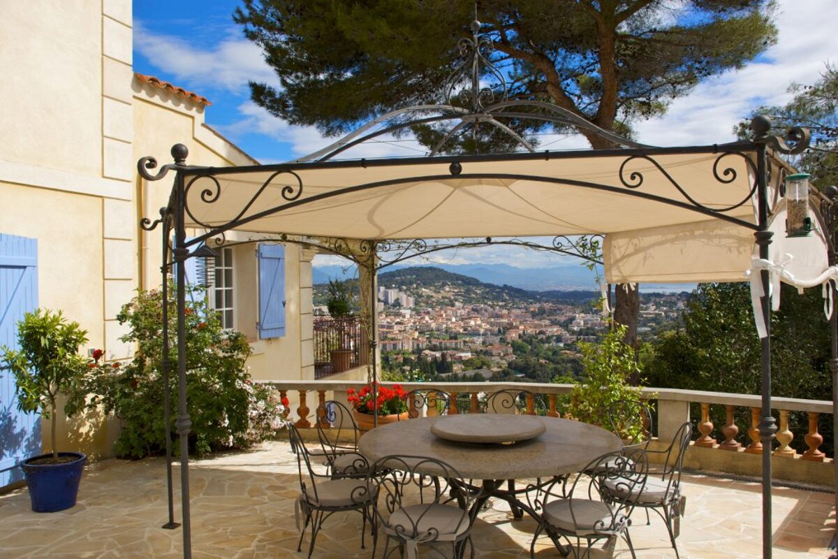 A table and chairs under a canopy overlooking a city