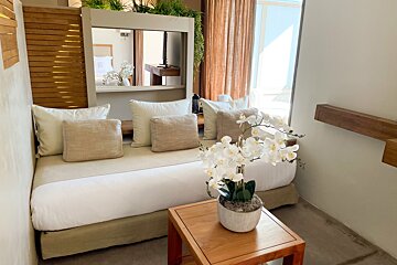 A room with a bed and a table with flowers on it