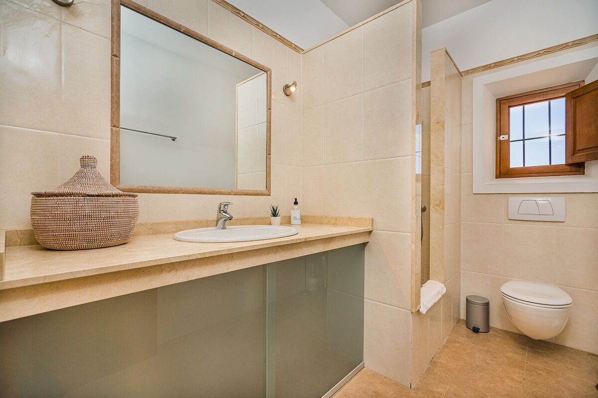 A bathroom with a sink a toilet and a mirror