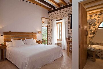 A bedroom with a large bed and a wooden headboard