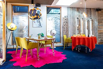 A room with a table and chairs and a pink rug