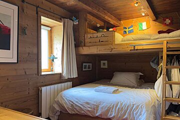A bedroom with a bunk bed and a picture of a red car on the wall