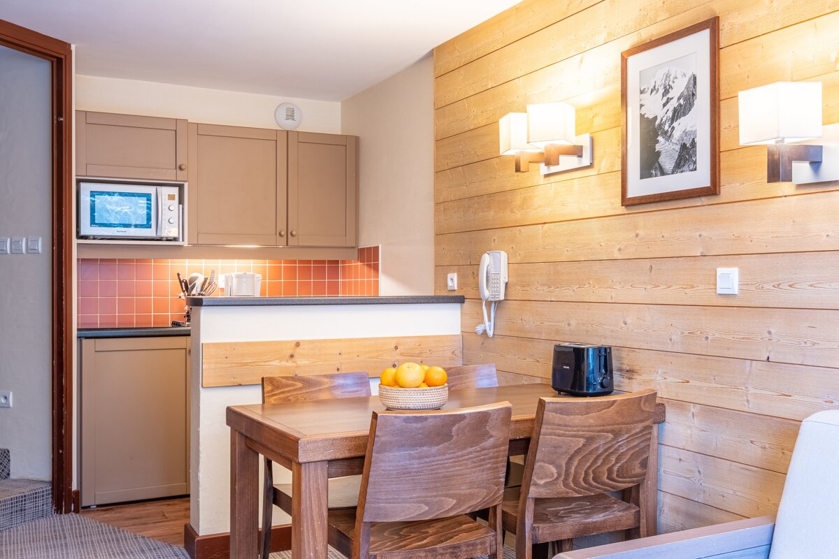 A kitchen with a table and chairs and a toaster
