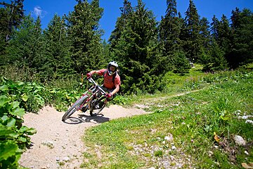 a mountain biker taking a corner on a berm in la plagne