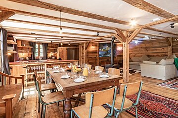 A dining room table with plates and glasses on it