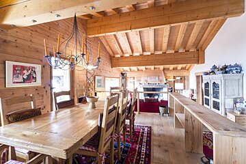 A dining room with a long wooden table and chairs