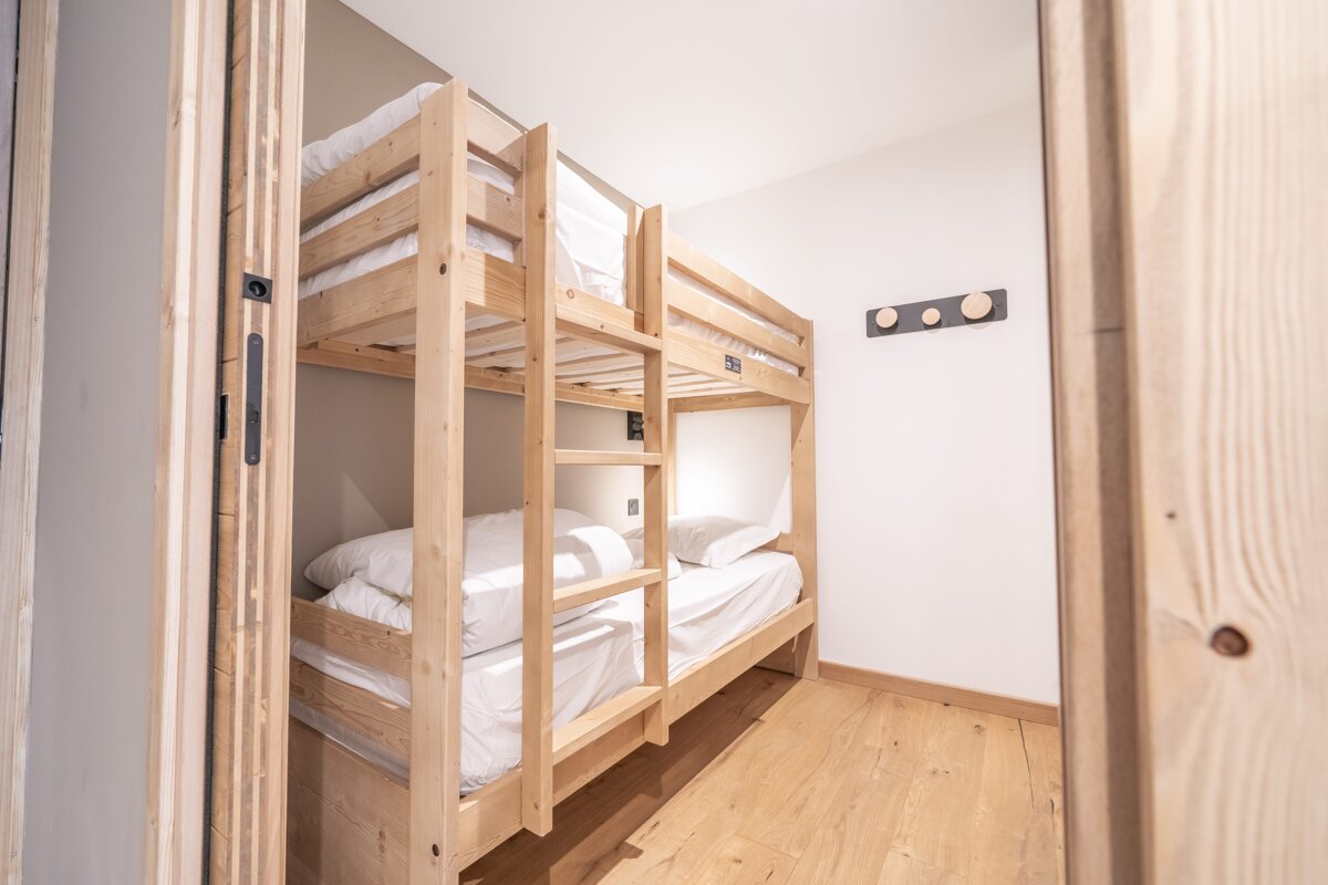 A bunk bed in a room with a hook on the wall