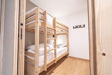 A bunk bed in a room with a hook on the wall