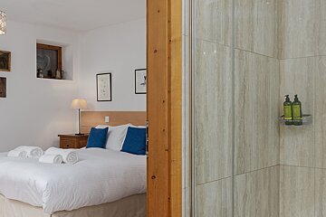 A bedroom with a king size bed and a walk in shower