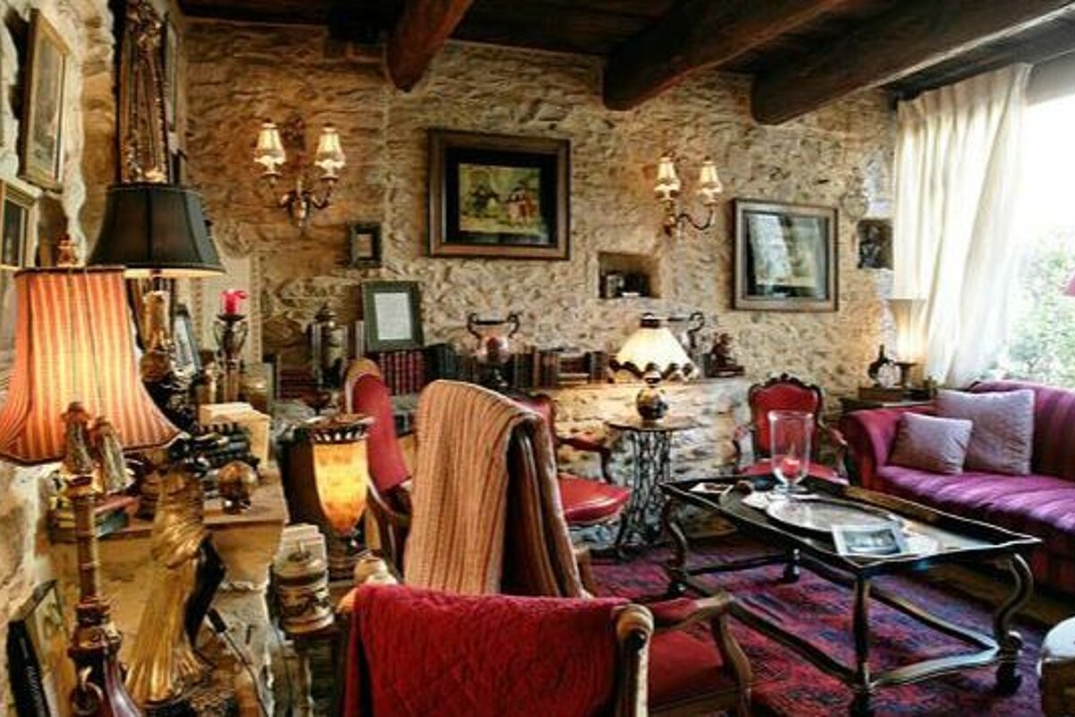 Stone walled living room with red sofas and a variety of different lamps
