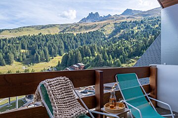 Two chairs on a balcony overlooking a mountain range