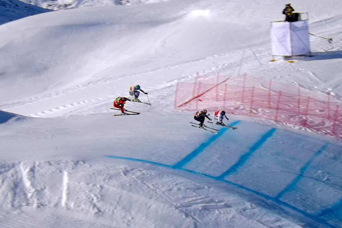 skiers jumping on a ski cross world cup track