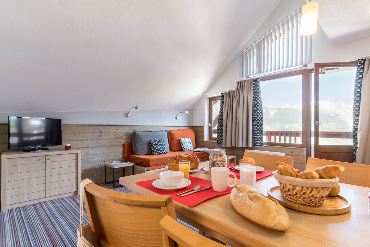 A dining room table with a basket of bread on it