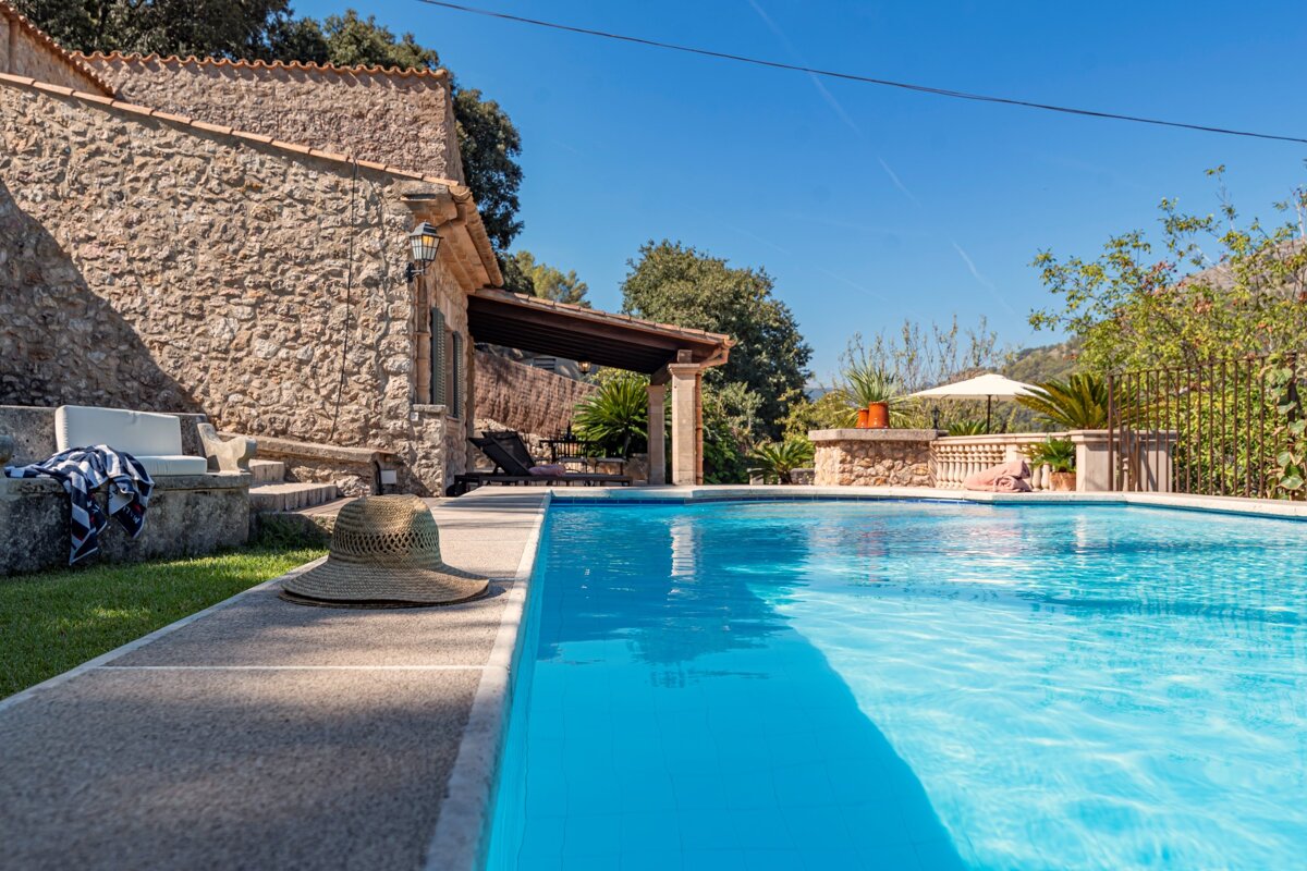 A straw hat sits on the edge of a swimming pool