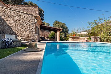 A straw hat sits on the edge of a swimming pool