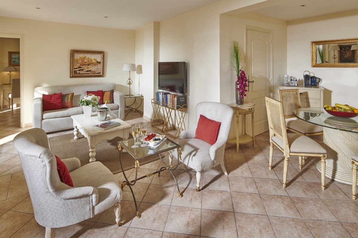 A living room with a white couch and chairs