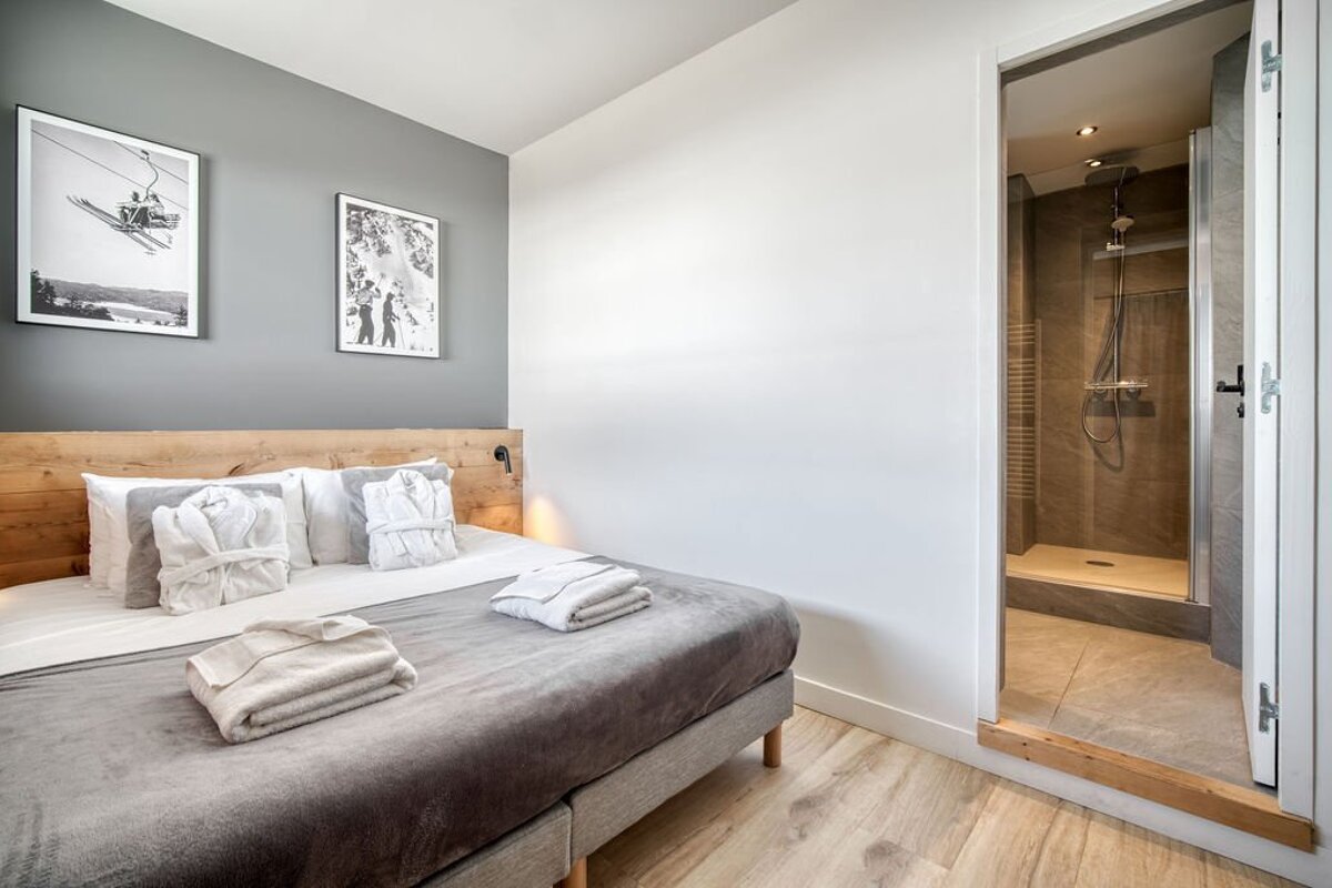 A bedroom with a bed and a picture of a ski lift on the wall