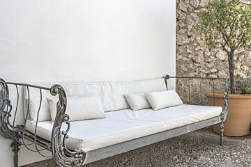 A couch with white cushions sits in front of a white wall