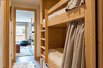 A bunk bed in a hallway leading to a living room