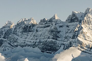 A snowy mountain with a blue sky in the background