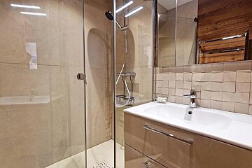 A bathroom with a sink and a walk in shower