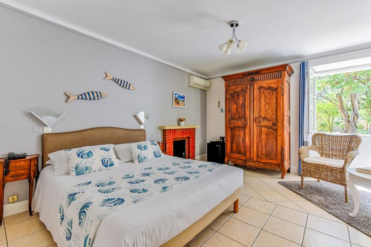 A bedroom with a large bed and a wicker chair