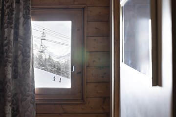 A ski lift is visible through the window of a cabin