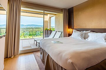 A hotel room with a large bed and a balcony