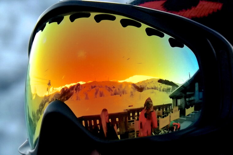 the sunset reflected in some ski goggles