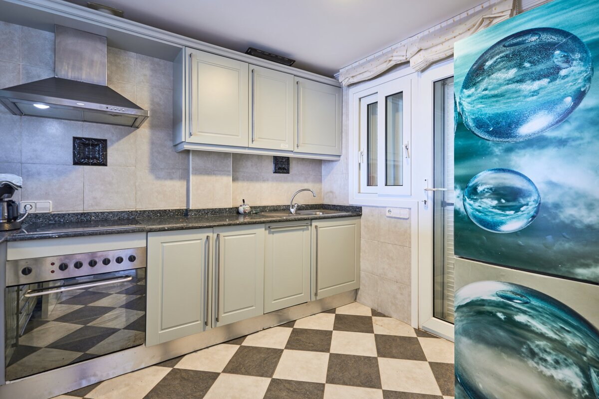 A kitchen with a picture of water bubbles on the refrigerator