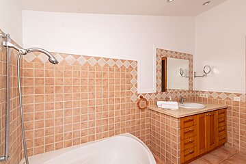 A bathroom with a bathtub sink and mirror