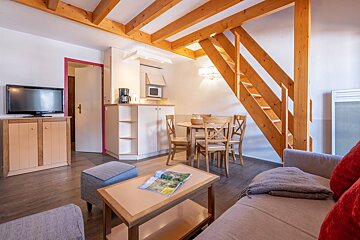 A living room with a staircase leading up to the second floor
