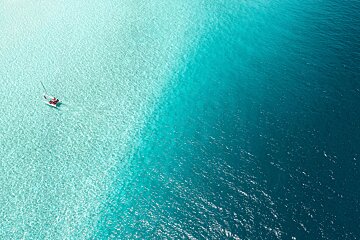 An aerial view of a boat in the middle of the ocean