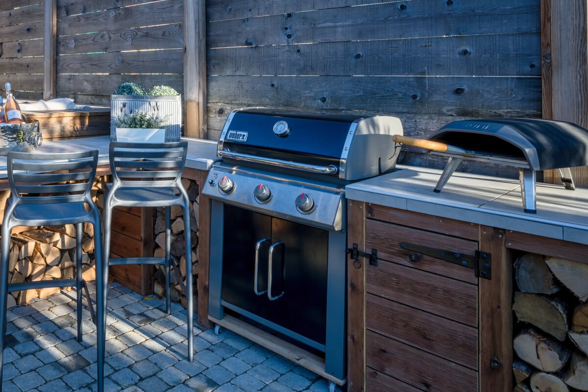 A weber grill is sitting on a counter outside
