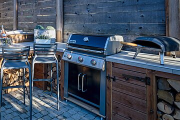 A weber grill is sitting on a counter outside