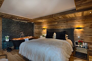 A bedroom with a bathtub in the corner