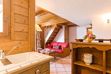 A living room with a red couch and stairs